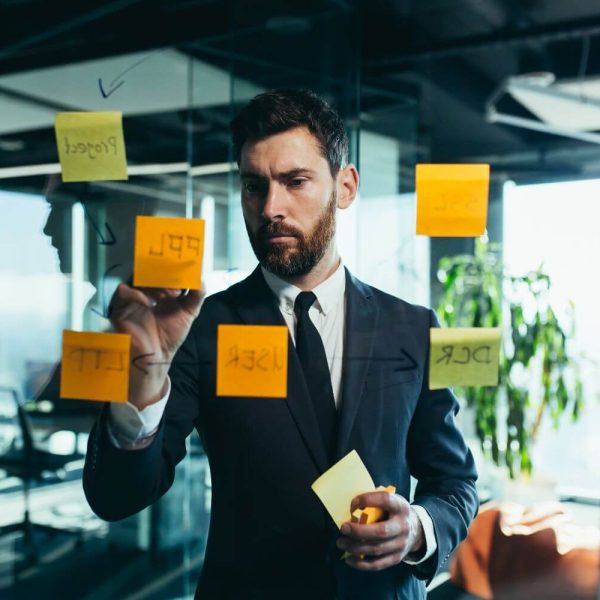 businessman-in-reflection-at-a-glass-task-board-h-2022-12-08-04-13-27-utc
